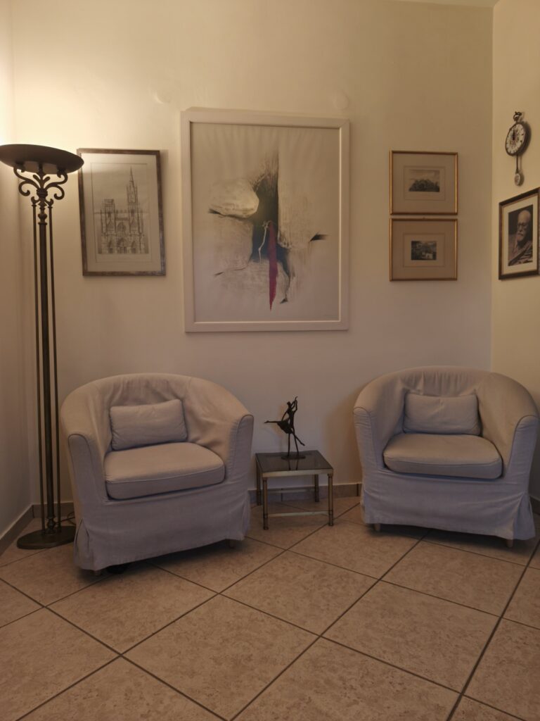 Ήρεμος θεραπευτικός χώρος με πολυθρόνες, διακριτική διακόσμηση και ζεστό φωτισμό